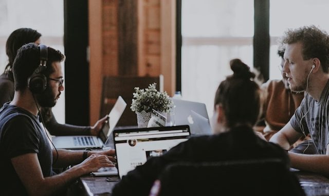 Group of 5 people working with computers